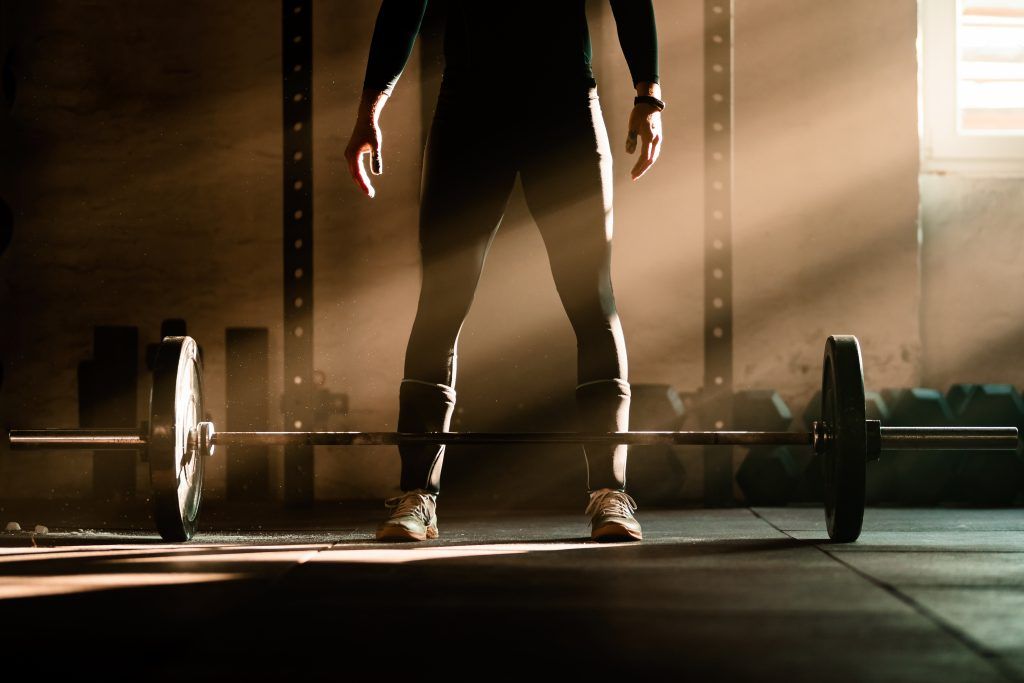 exercising with barbell in a gym.